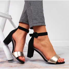 Sandalias de mujer negras y doradas en el puesto eVento. 5