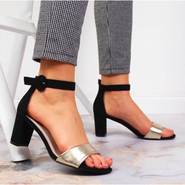 Sandalias de mujer negras y doradas en el puesto eVento. 6