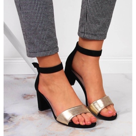 Sandalias de mujer negras y doradas en el puesto eVento. 7