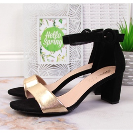 Sandalias de mujer negras y doradas en el puesto eVento. 2