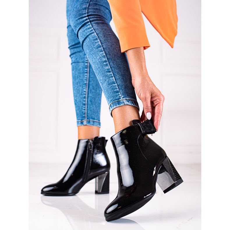 Botas Shelovet de mujer elegante en un poste negro decorativo 1